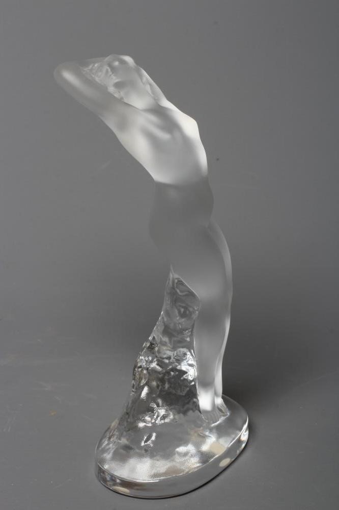 A LALIQUE "DANSEUSE BRAS LEVES", modern, the frosted nude figure leaning against a clear rocky Image