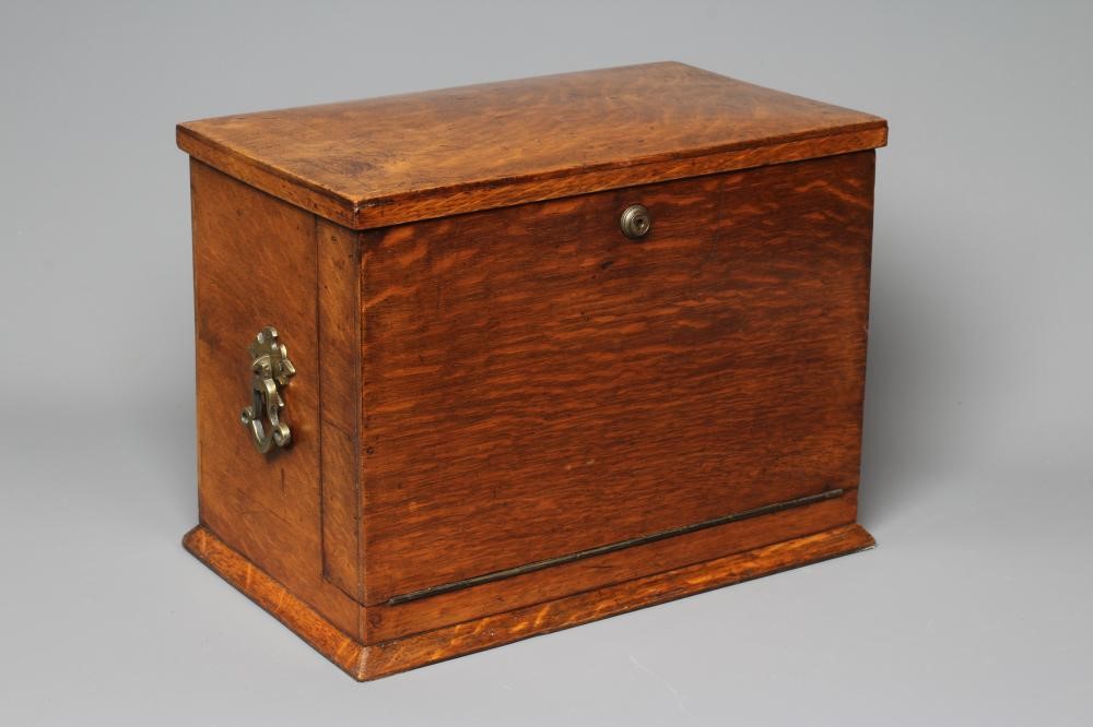 AN EDWARDIAN OAK STATIONERY BOX of oblong form with lightly domed hinged top and two brass handles Image