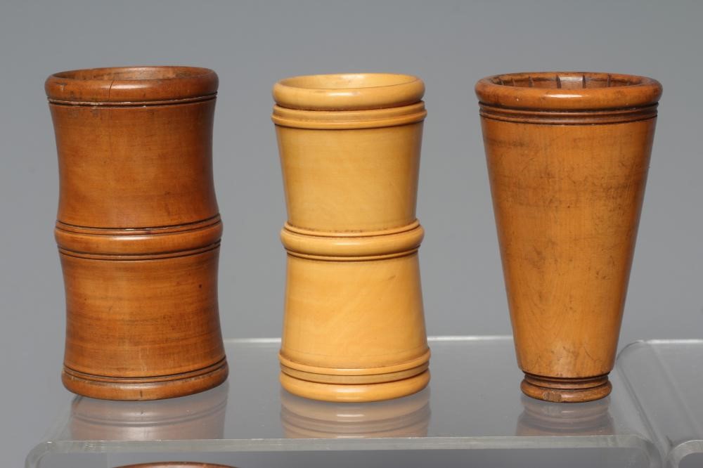 NINE 19TH CENTURY TREEN AND LIGNUM VITAE DICE SHAKERS of waisted form with exterior mouldings and Image