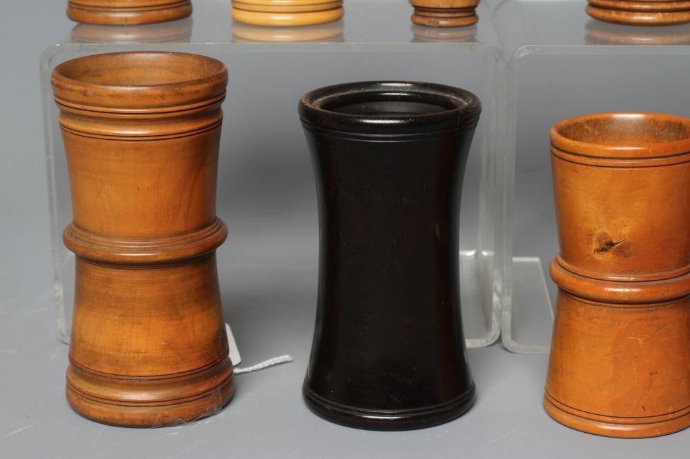 NINE 19TH CENTURY TREEN AND LIGNUM VITAE DICE SHAKERS of waisted form with exterior mouldings and Image