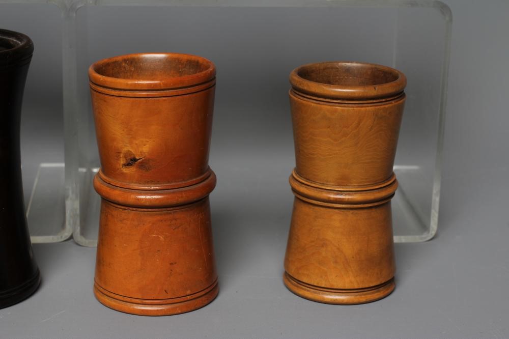 NINE 19TH CENTURY TREEN AND LIGNUM VITAE DICE SHAKERS of waisted form with exterior mouldings and Image