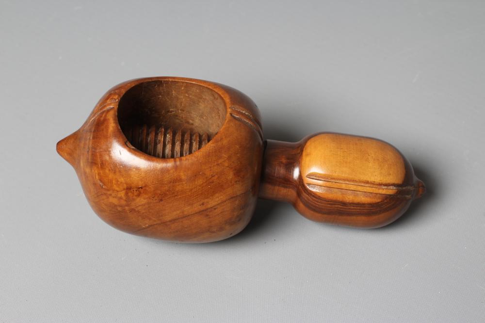 A 19TH CENTURY FRUITWOOD NUTCRACKER, possibly French, with circular opening and traditional screw Image