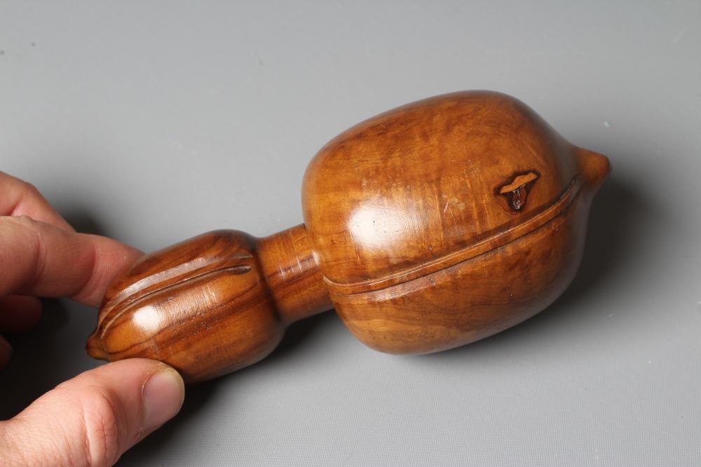 A 19TH CENTURY FRUITWOOD NUTCRACKER, possibly French, with circular opening and traditional screw Image
