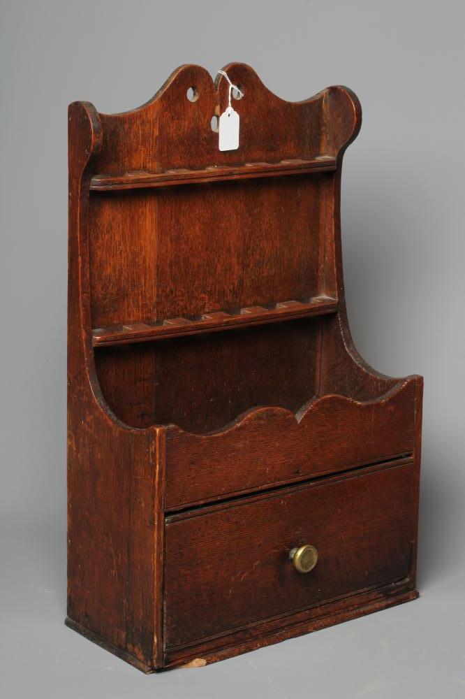 A GEORGE III OAK SPOON RACK, the boarded back with waved pediment above two shelves for spoons, the Image