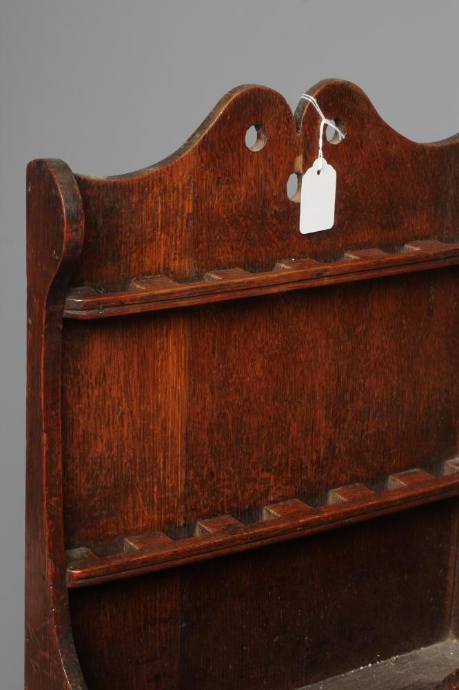 A GEORGE III OAK SPOON RACK, the boarded back with waved pediment above two shelves for spoons, the Image