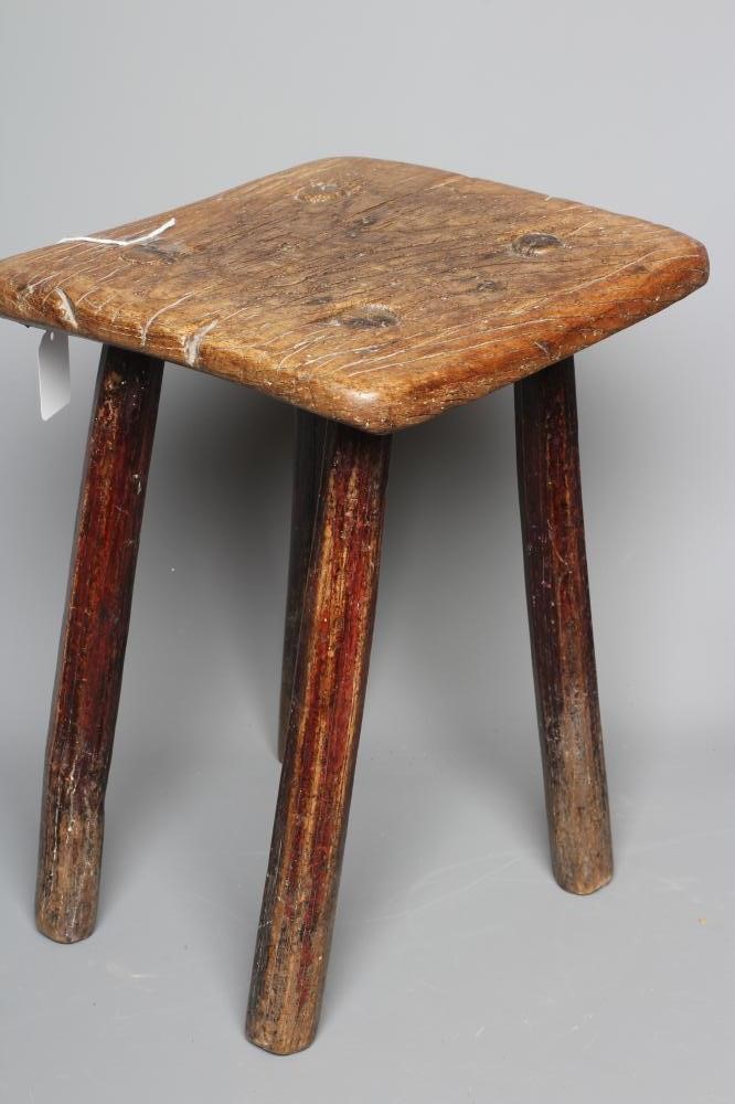 A 19TH CENTURY ASH AND ELM MILKING STOOL, the oblong seat raised on four circular tapering legs, 13 Image