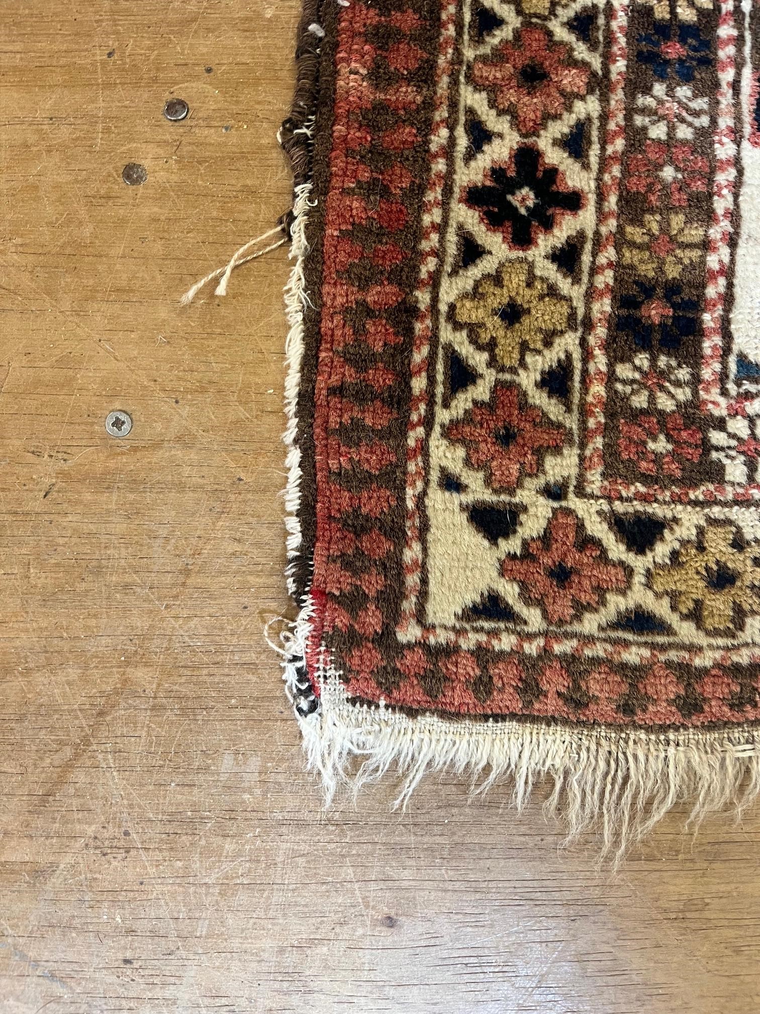 AN ANTIQUE CAUCASIAN RUG, early 20th century, the ivory and red field with five guls in indigo and Image