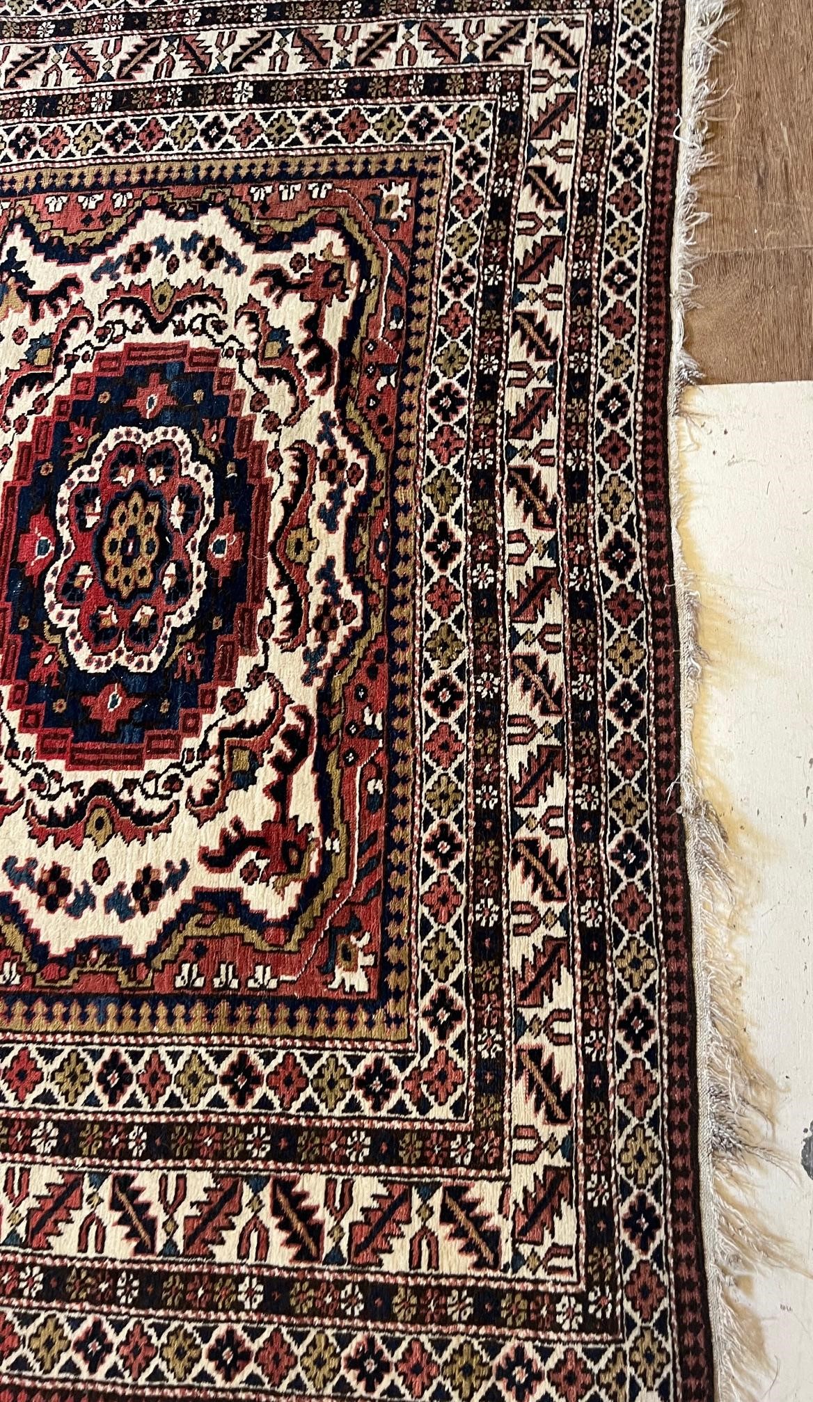 AN ANTIQUE CAUCASIAN RUG, early 20th century, the ivory and red field with five guls in indigo and Image