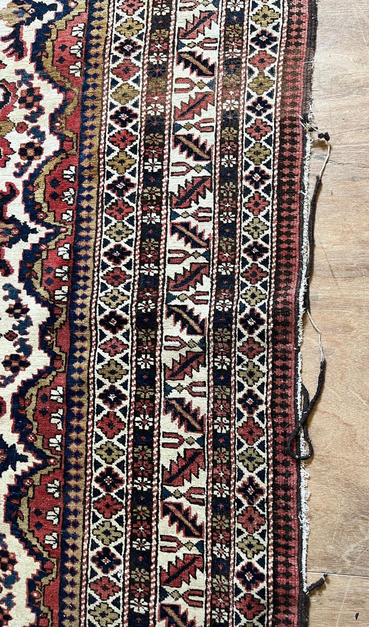AN ANTIQUE CAUCASIAN RUG, early 20th century, the ivory and red field with five guls in indigo and Image