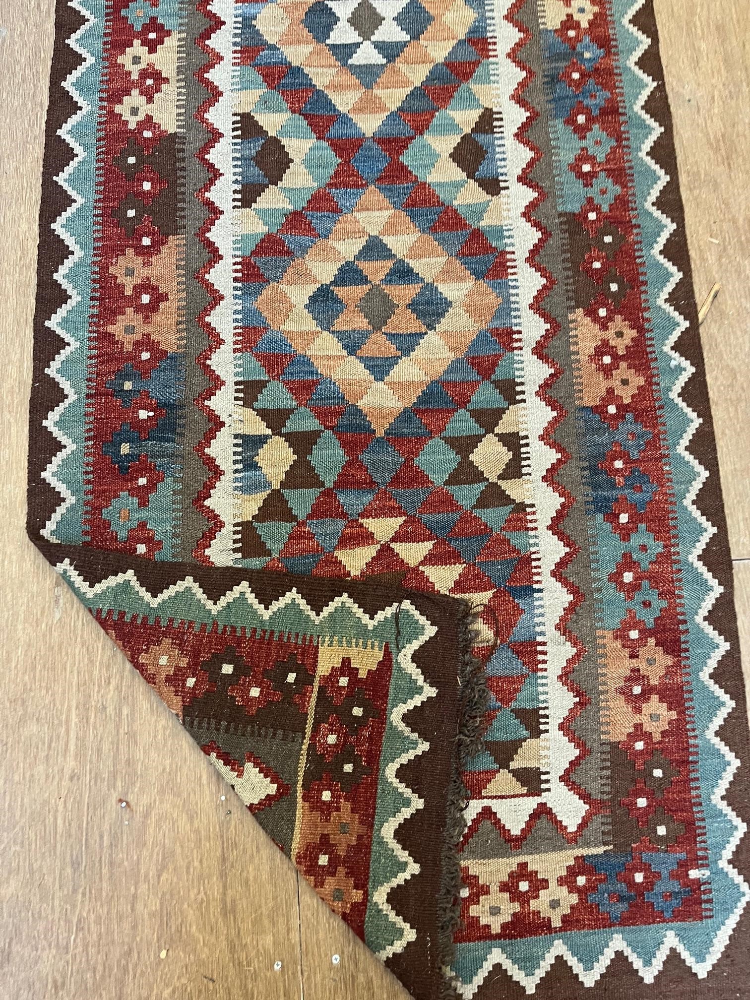 AN AFGHAN KILM RUNNER, modern, the ivory field with five diamond patterned guls in pale green, blue Image