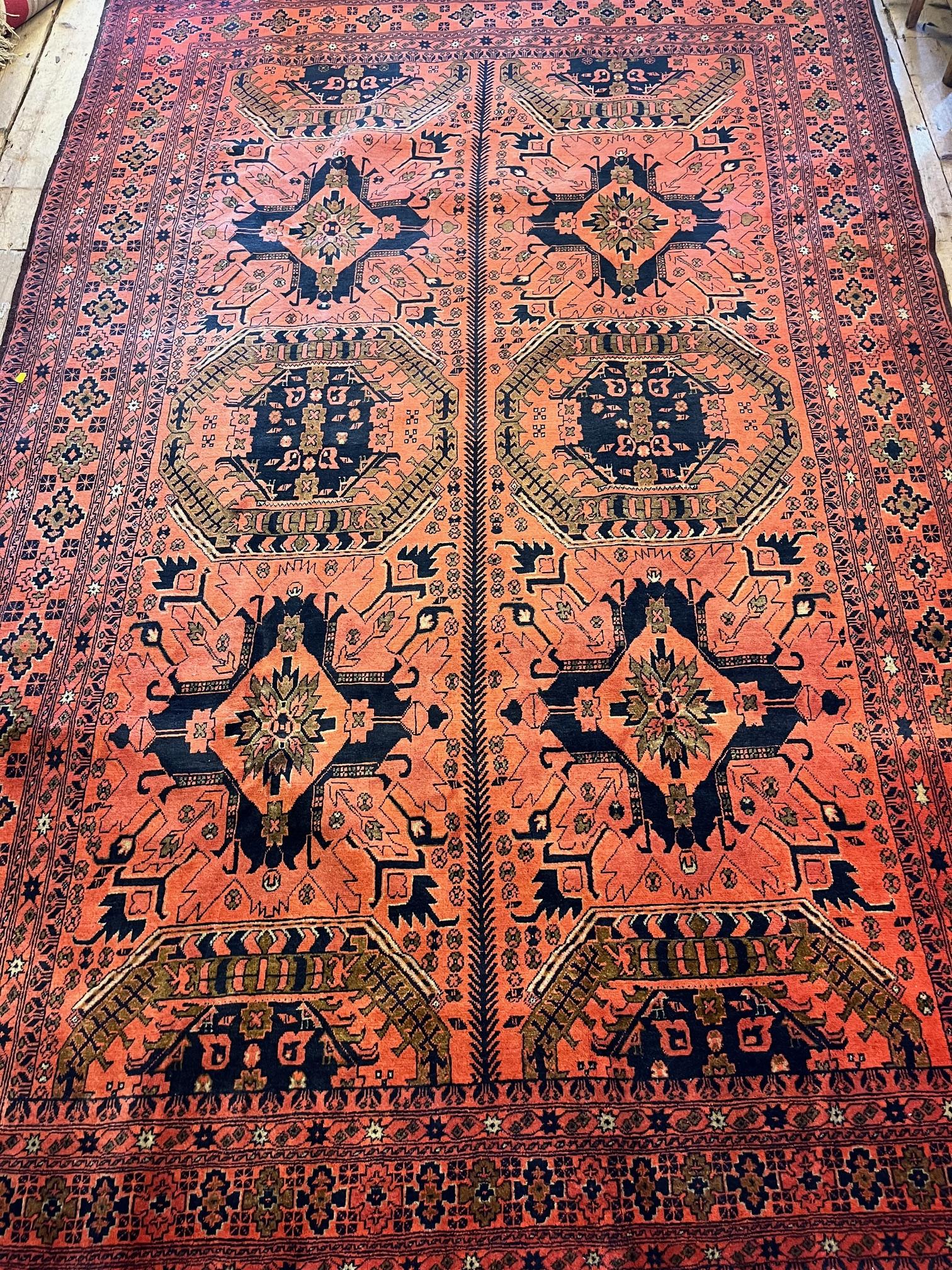 AN AFGHAN RUG, modern, the red field with central division and two rows of alternating indigo guls Image
