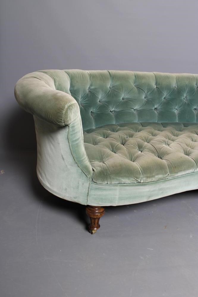 A VICTORIAN WALNUT FRAMED CHESTERFIELD SOFA of curved outline, button upholstered in pale green Image