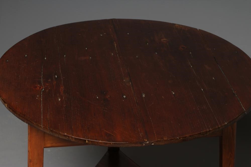 A STAINED PINE CRICKET TABLE, 19th century, the circular plank top and plain frieze on square Image