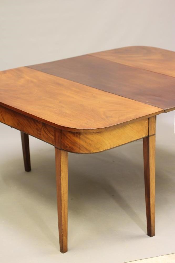 A GEORGIAN MAHOGANY DINING TABLE, c.1800, of rounded oblong form with detachable leaf, plain frieze Image