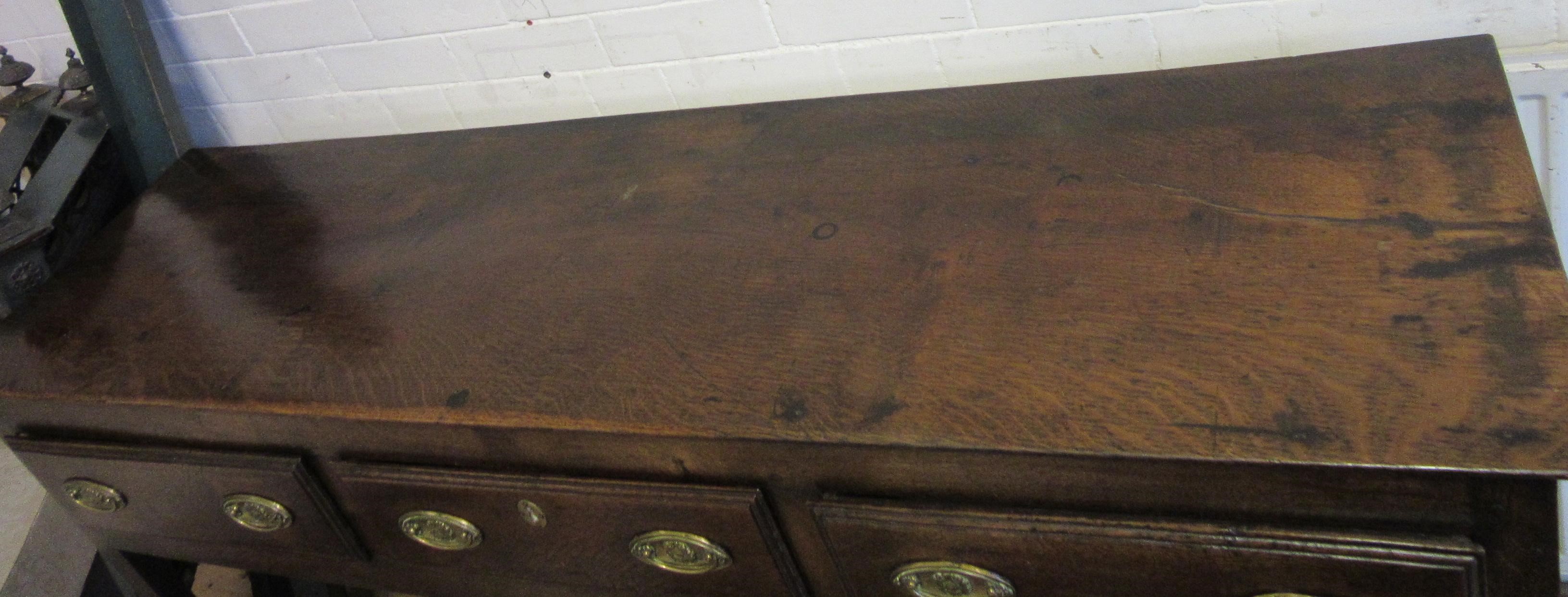 A GEORGIAN OAK POTBOARD DRESSER, early 19th century, the single plank top over three moulded edged Image