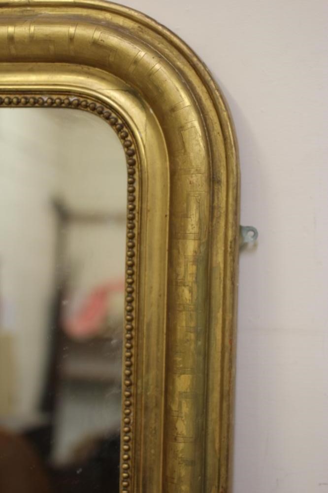 A VICTORIAN GILT GESSO OVERMANTEL MIRROR, the arched plate within a moulded and beaded border with Image