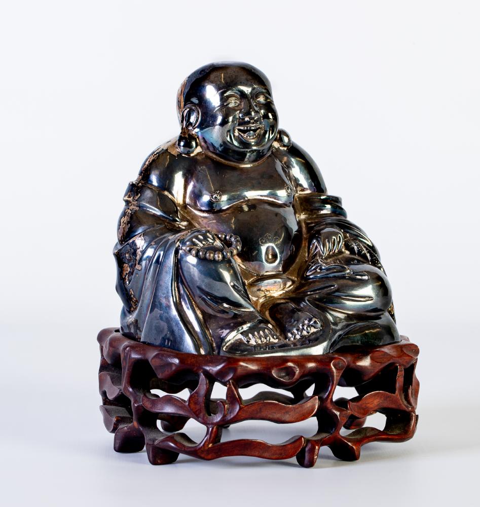A CHINESE WHITE METAL FIGURE OF PU TAI holding a string of beads Image