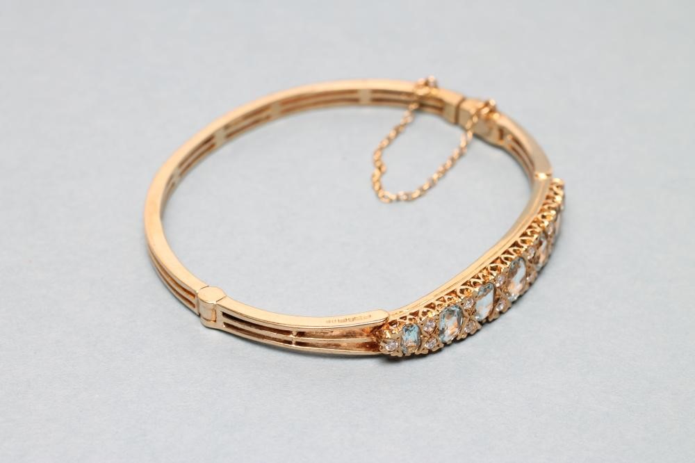 AN AQUAMARINE AND DIAMOND STIFF HINGED BANGLE Image