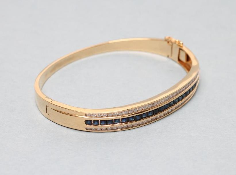 A SAPPHIRE AND DIAMOND STIFF HINGED BANGLE Image