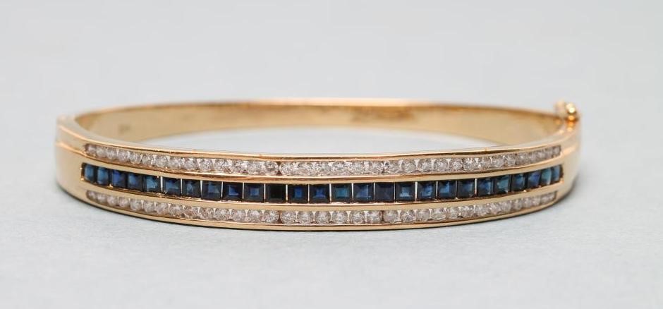 A SAPPHIRE AND DIAMOND STIFF HINGED BANGLE Image