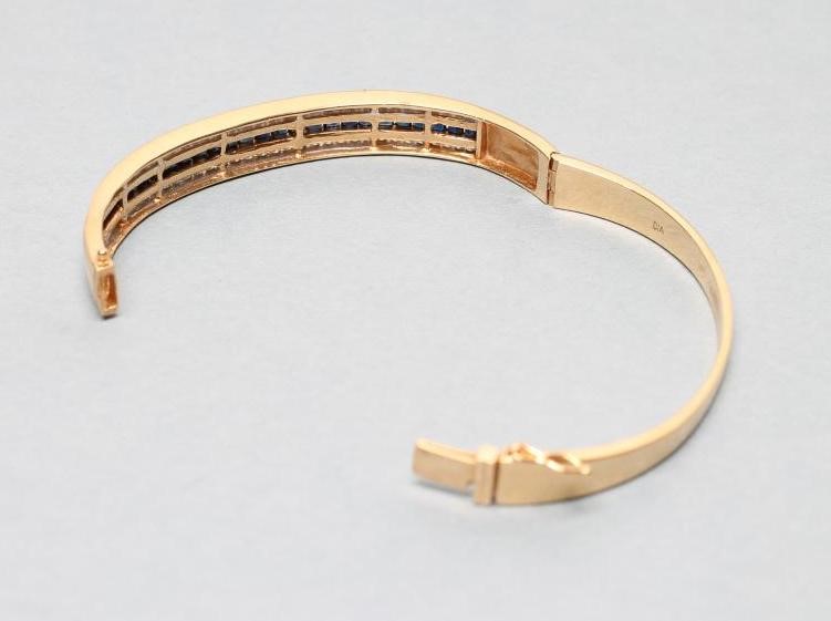 A SAPPHIRE AND DIAMOND STIFF HINGED BANGLE Image