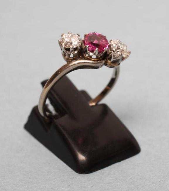 A THREE STONE RUBY AND DIAMOND CROSSOVER RING Image