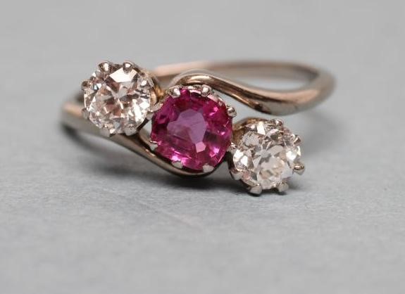 A THREE STONE RUBY AND DIAMOND CROSSOVER RING Image