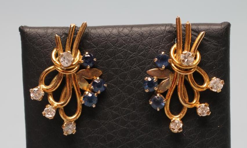 A PAIR OF SAPPHIRE AND DIAMOND EAR STUDS as stylised looped sprays claw set with four small diamonds Image