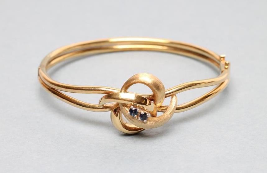 A 9CT GOLD STIFF HINGED BANGLE Image