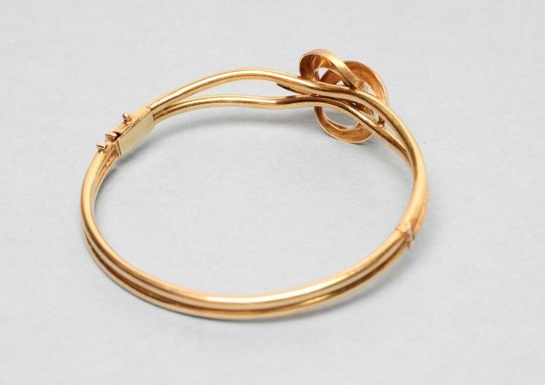 A 9CT GOLD STIFF HINGED BANGLE Image