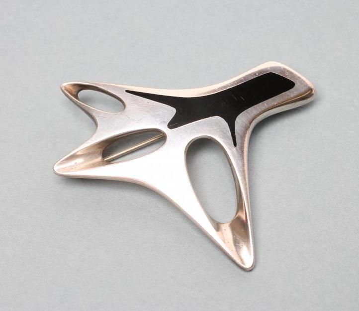 A GEORG JENSEN SILVER BROOCH designed by Henning Koppel of abstract open form with a polished black Image