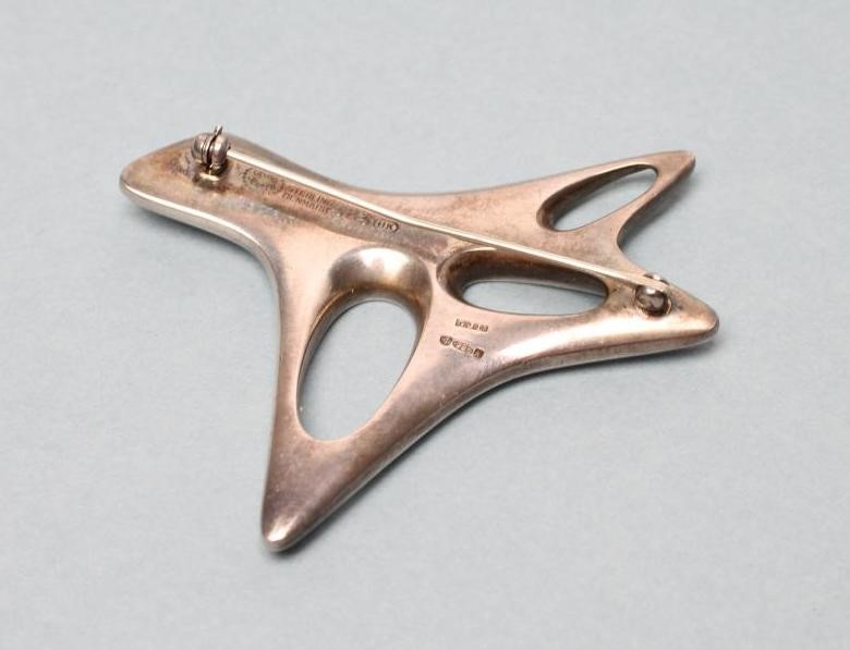 A GEORG JENSEN SILVER BROOCH designed by Henning Koppel of abstract open form with a polished black Image