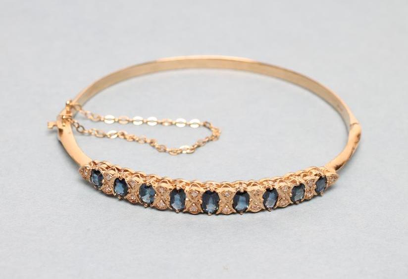 A SAPPHIRE AND DIAMOND STIFF HINGED BANGLE Image