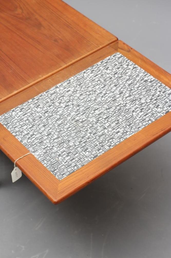 A RETRO MID CENTURY TEAK COFFEE TABLE of oblong form with sliding end extensions Image