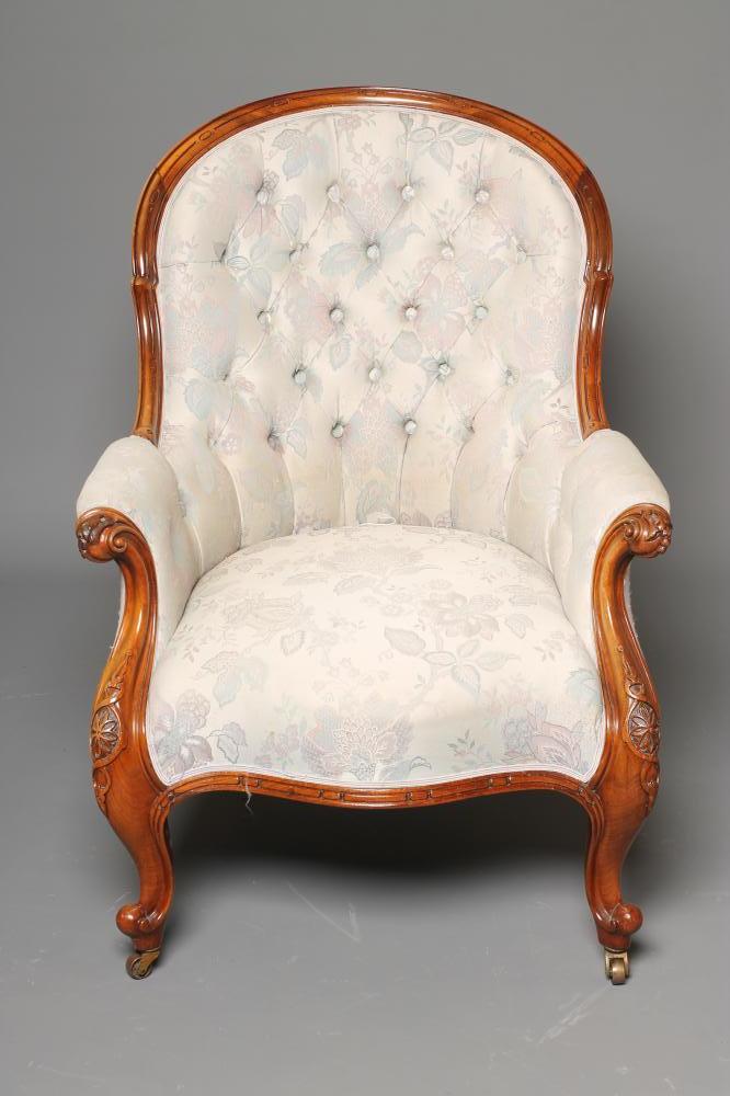 A VICTORIAN WALNUT FRAMED SALON ARMCHAIR of spoon back form button upholstered in an ivory floral Image