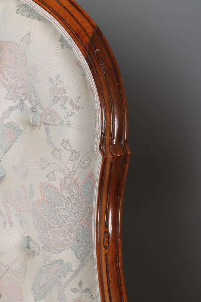 A VICTORIAN WALNUT FRAMED SALON ARMCHAIR of spoon back form button upholstered in an ivory floral Image