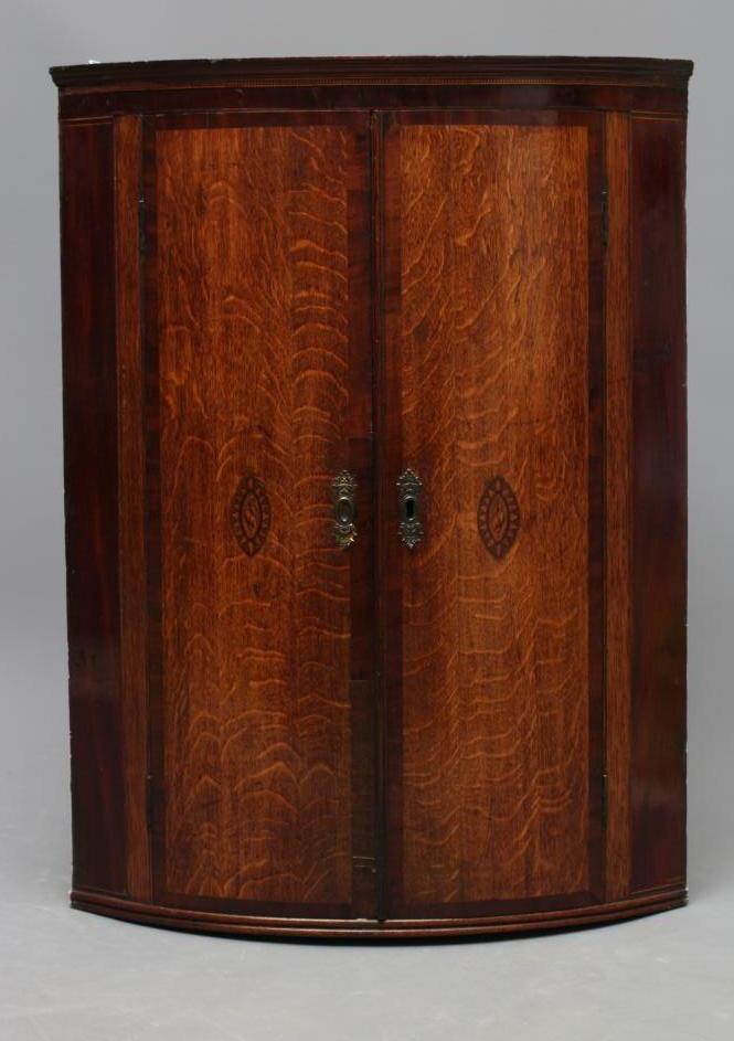 A GEORGIAN OAK AND MAHOGANY BANDED CORNER CUPBOARD Image