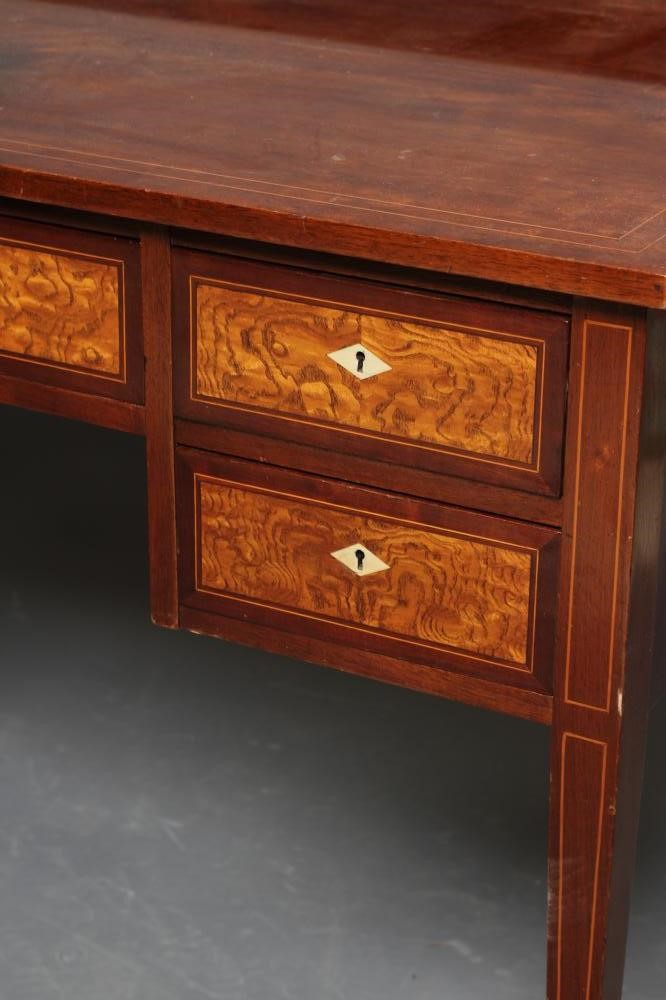 AN EDWARDIAN MAHOGANY KNEEHOLE DRESSING TABLE of oblong form with stringing and three quarter Image