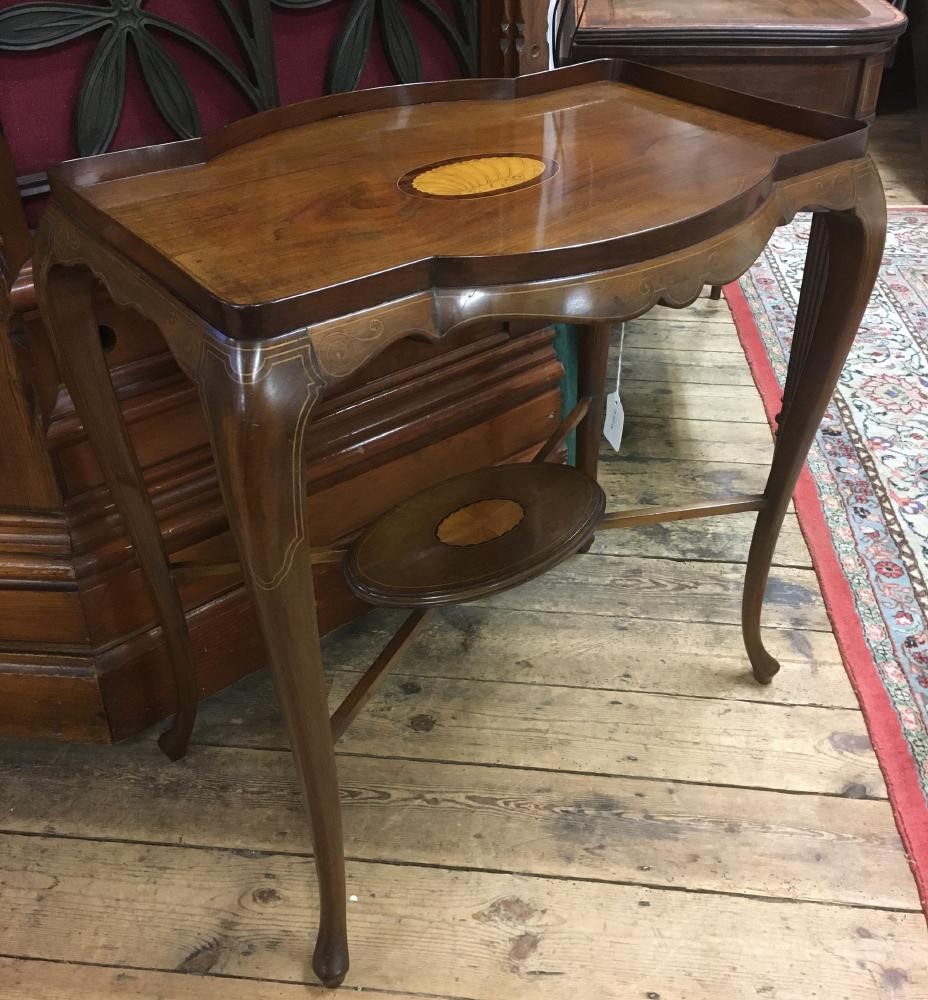 AN EDWARDIAN MAHOGANY OCCASIONAL TABLE of shaped rounded oblong form with stringing Image
