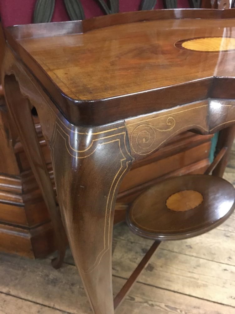 AN EDWARDIAN MAHOGANY OCCASIONAL TABLE of shaped rounded oblong form with stringing Image