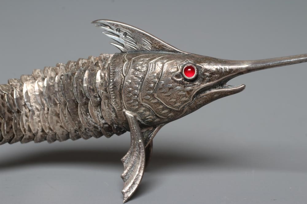 A SPANISH SILVER ARTICULATED SWORDFISH with chased detailing and collet set ruby glass cabochon Image