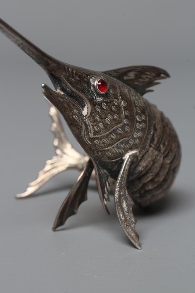 A SPANISH SILVER ARTICULATED SWORDFISH with chased detailing and collet set ruby glass cabochon Image