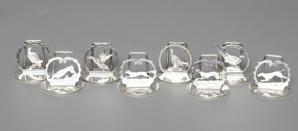 A COMPOSITE SET OF EIGHT SILVER NOVELTY MENU/PLACE CARD HOLDERS Image
