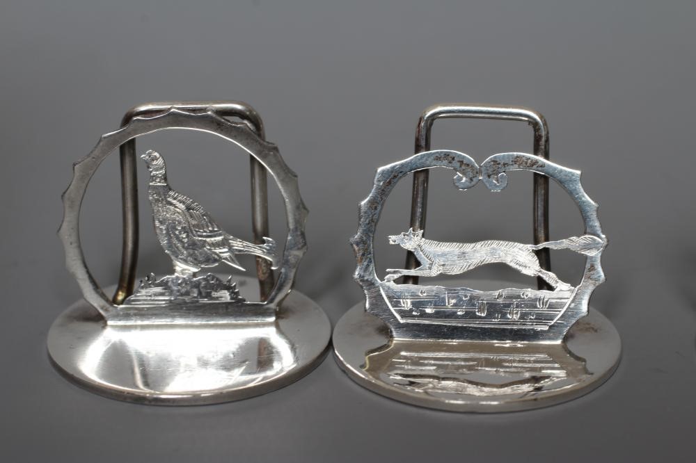 A COMPOSITE SET OF EIGHT SILVER NOVELTY MENU/PLACE CARD HOLDERS Image