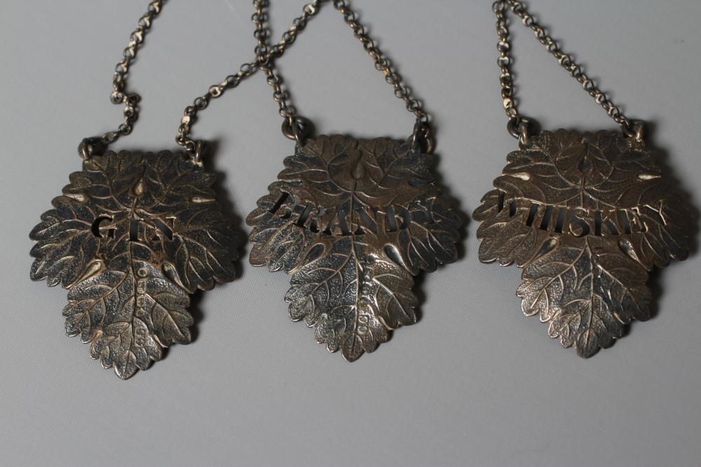 A SET OF THREE VICTORIAN SILVER VINE LEAF BOTTLE LABELS by Colen Hewer Cheshire, Birmingham 1879, Image