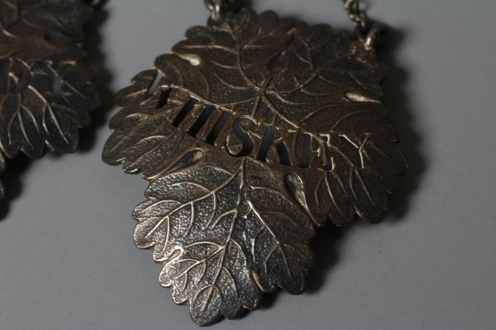 A SET OF THREE VICTORIAN SILVER VINE LEAF BOTTLE LABELS by Colen Hewer Cheshire, Birmingham 1879, Image