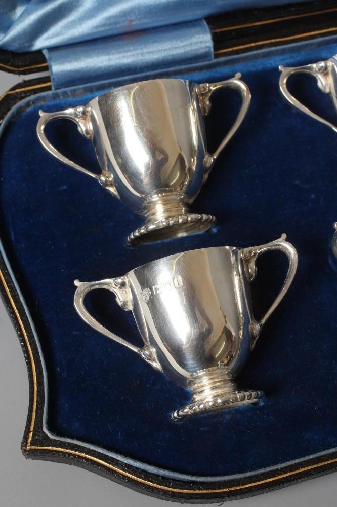A SET OF SIX EDWARDIAN SILVER MINIATURE TWO HANDLED TROPHY CUPS by Goldsmith's & Silversmith's Co. Image