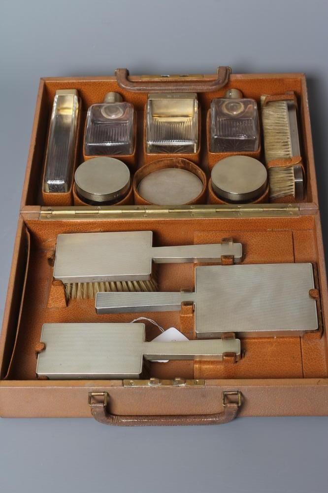 AN ART DECO ELEVEN PIECE SILVER TRAVELLING DRESSING SET Image