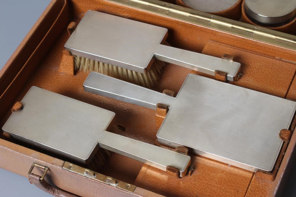 AN ART DECO ELEVEN PIECE SILVER TRAVELLING DRESSING SET Image