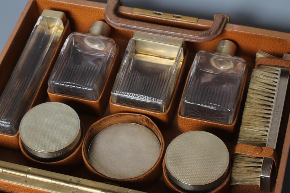 AN ART DECO ELEVEN PIECE SILVER TRAVELLING DRESSING SET Image